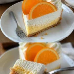 Erfrischender Orangencreme Käsekuchen mit Sahne auf einem Teller
