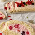 Beeren-Baiserrolle mit frischen Beeren und Baiser-Haube auf einem Teller